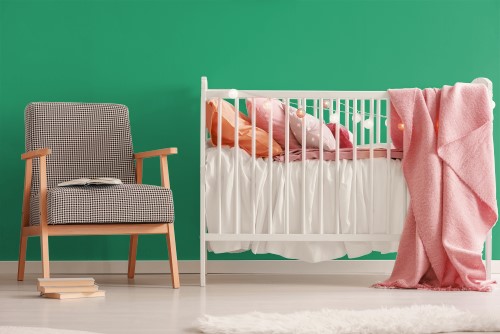 Στην φωτογραφία απεικονίζεται η απόχρωση στον τοίχο ενός δωματίου με μια κούνια για μωρό